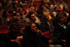 05. Im Halbdunkel verfolgt das Publikum die Filmausschnitte